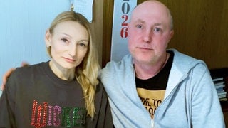 Serhii und Nataliia Shkola sitzen gemeinsam an einem Tisch.