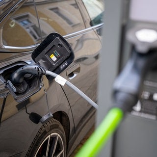 Ein Elektroauto hängt an einer Elektro-Ladesäule in der Innenstadt. Das Interesse an Elektroauto hat einer Forsa-Umfrage zufolge zugenommen. Höhere Energiepreise könnten einen Wandel bewirken.