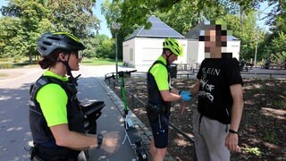 Die Fahrradpolizisten Aurelia Hildebrandt und Sebastian Eberhardt haben im Stuttgarter Schlosspark einen Mann mit einem E-Scooter angehalten.