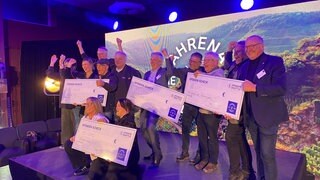 Gewinnervereine mit ihren großen Schecks freuen sich: Das Spendenshuttle im Ahrtal hat Geld an zehn Projekte gegeben bei der Ahrena der Ideen.