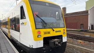Die gelbe Hermann-Hesse-Bahn steht auf den Schienen.