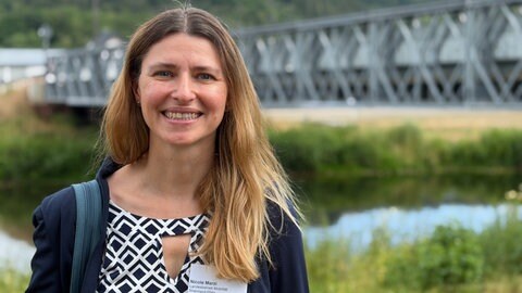 Nicole Marzi vom Landesbetrieb Mobilität Rheinland-Pfalz steht vor einer Behelfsbrücke im Ahrtal