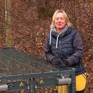 Frau mit einem Käfig im Wald