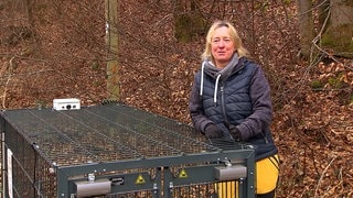 Frau mit einem Käfig im Wald