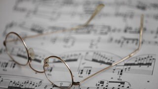 Symbolbild Musik Üben: Ein Notenblatt mit Lesebrille