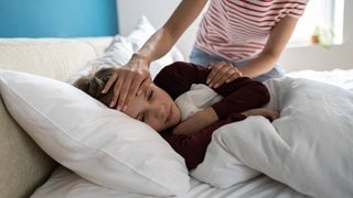 Kind liegt krank im Bett. Forscher haben das Rätsel um das Entzündungssyndrom gelöst, das bei Kindern nach einer Infektion mit Corona auftreten kann.