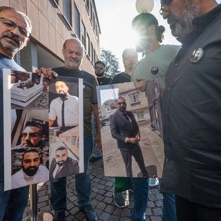 Hinterbliebene des getöteten Zugbegleiters Serkan Çalar sind bereits am Mittwochmorgen vor dem Landgericht Zweibrücken, wo am Donnerstag der Prozess gegen den Mann, der seinen Tod zu verantworten hat, und zeigen Bilder ihres verstorbenen Freundes, Familienmitgliedes und Arbeitskollegen.