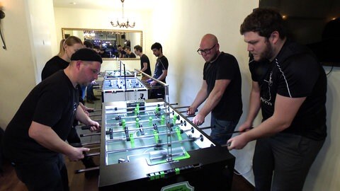 Timo Zipper spielt mit drei Personen Tischkicker.