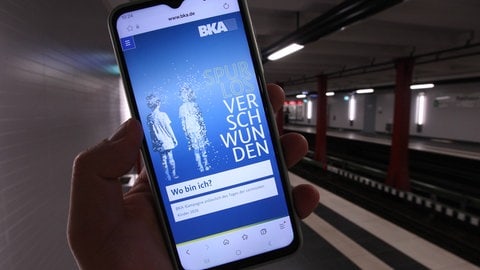 Ein Handy zeigt eine Suchmeldung nach vermissten Kindern.