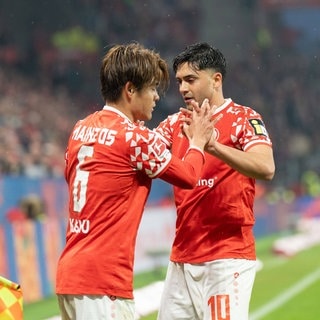 Kaishu Sano und Nadiem Amiri vom 1. FSV Mainz 05 klatschen sich ab.