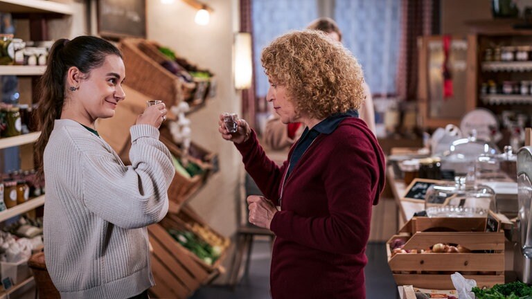 Jenny (Julia Obst) und Bea (Christiane Brammer) prosten sich mit Schnaps zu
