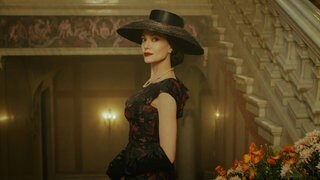 Film "Maria" von Pablo Larraín: Angelina Jolie als Maria Callas blickt den Betrachter über die Schulter an. Sie trägt ein schwarz-gemustertes Abendkleid mit Hut und posiert auf einer Treppe.