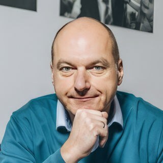 Politikberater Frank Stauss hält die Faust ans Kinn und schaut in die Kamera. 