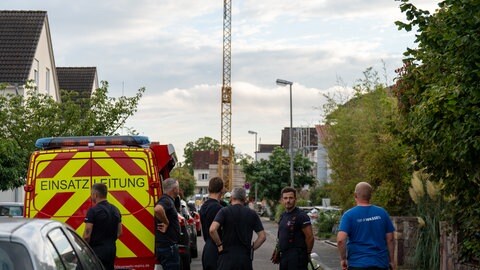Baukran steht in einer Straße in Mainz-Laubenheim. Davor Einsatzkräfte. Der Kran droht umzustürzen. Mehrere Häuser wurden evakuiert. 