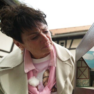 Sonja Faber-Schrecklein steht in eine Burghof und schaut in ein Diorama.