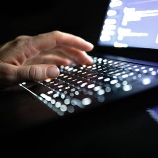 Finger tippen auf der Tastatur eines Notebooks 