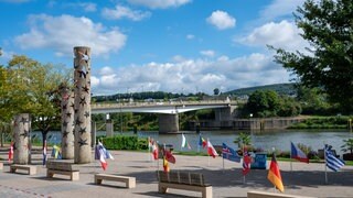 Die Fahnen von EU-Mitgliedsstaaten wehen vor den Nationensäulen in Schengen.  