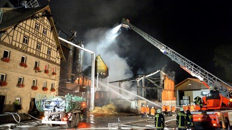 Einsatzkräfte der Feuerwehr löschen einen brennenden Mühlenbetrieb. Nach dem Brand war verunreinigtes Löschwasser in die Jagst gespült worden und hatte ein Fischsterben ausgelöst