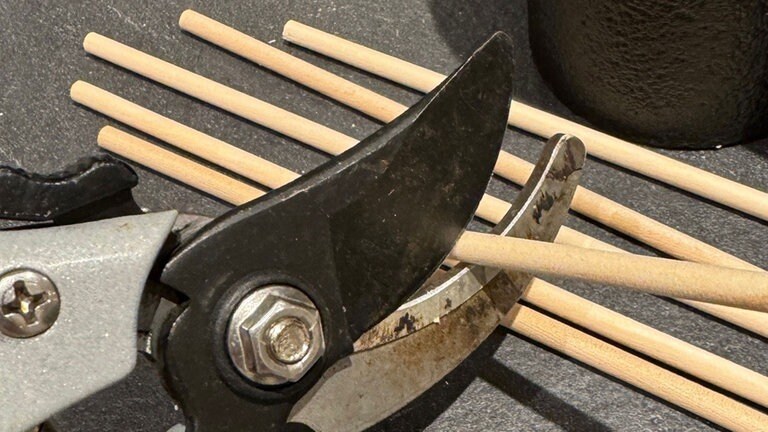Die Holzstäbe, entweder mit einer kleinen Säge oder mit einer Gartenschere, auf die Länge der Zwischenräume zuschneiden.