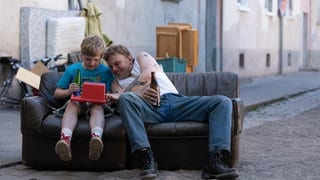  Christian (Camille Loup Moltzen, li.) und sein Vater Ottes (Leonard Kunz, re.), der als Möbelpacker arbeitet - die beiden haben Spaß mit Fundstücken und Weggeworfenem.