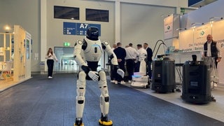 In einer Messehalle in Friedrichshafen ist ein Roboter zu sehen und ein Dampfreiniger.