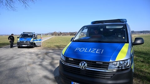 Polizeifahrzeuge stehen in der Nähe eines landwirtschaftlichen Betriebs.