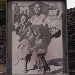 Foto von Sam Nzima im Hector-Pieterson-Gedenkmuseum: Mbuyisa Makhubu versucht 1976 in Soweto, den verwundeten Hector Pieterson, zu retten, begleitet von Hectors Schwester Antoinette. In einer nahegelegenen Klinik wurde der 13-Jährige für tot erklärt.