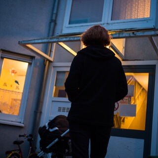 Eine Frau steht vor einem Frauenhaus. Die Frauenhäuser in Baden-Württemberg sind stark ausgelastet.