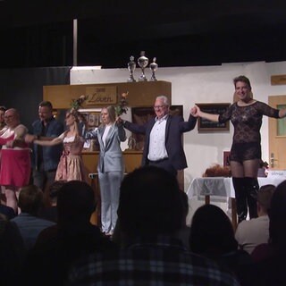 Bürgermeister und andere Personen auf Bühne bei Theateraufführung