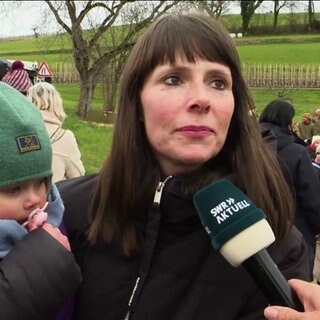 Eine Frau mit einem Baby wird interviewt