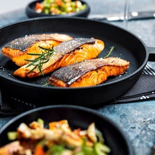 verschiedene Pfannen mit Fisch und Gemüse