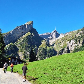 Wanderer auf dem Weg zum Seealpsee im Alpstein. Im Alpstein, oberhalb des Seealpsees sind Felsbrocken in die Nähe eines Wanderwegs gestürzt.