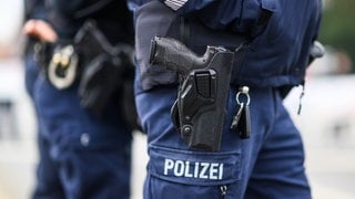 Zwei Polizisten mit Pistole und Handschellen (Symbolbild). Die Polizei hat jetzt mutmaßliche Einbrecher festgenommen. Sie könnten für mehrere Einbrüche im Raum Heilbronn und Crailsheim verantwortlich sein. 