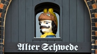 Schwedenkopf im Portal über der Tür des "Alten Schweden" in der Hansestadt Wismar: Woher kommt eigentlich der Ausdruck "alter Schwede"?