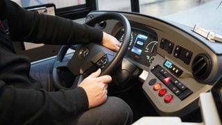 Eine Hand am Lenkrad eines Busses: Ein Busfahrer ist in Rammingen mit 1,8 Promille Alkohol im Blut unterwegs gewesen. Fahrgäste stoppten die Fahrt. (Symbolfoto)