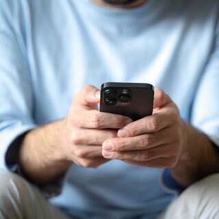 Ein Mann tippt auf einem Smartphone | Wie Betrüger bei Schockanrufen vorgehen und wie man sich schützen kann