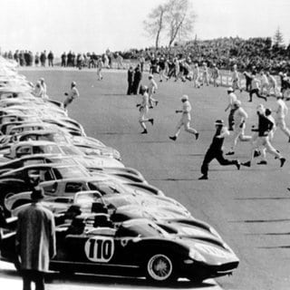 Das Archivfoto zeigt, wie am 19. Mai 1963 uf dem Nürburgring Fahrer bei einem Rennen zu ihren Rennwagen sprinten, die am Start stehen.