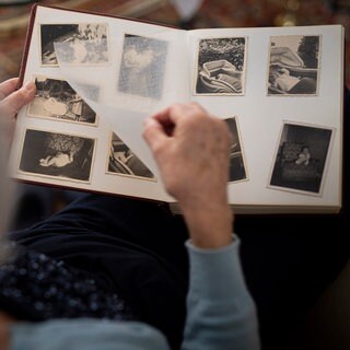 Eine Frau blättert in einem Fotoalbum