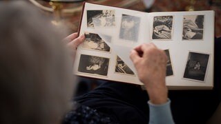 Eine Frau blättert in einem Fotoalbum