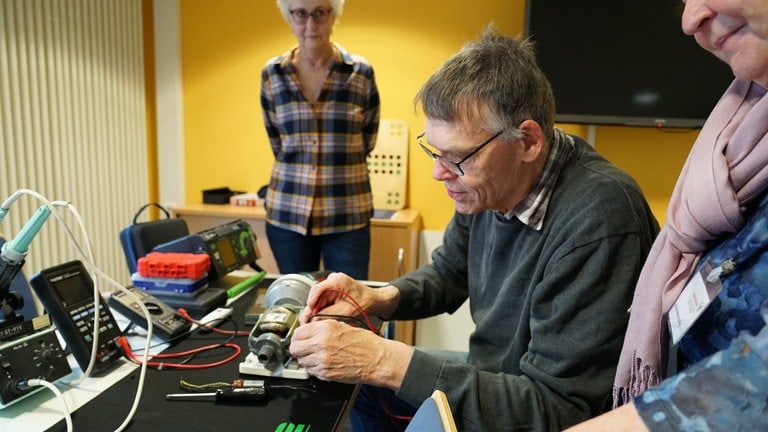 Klaus und Ursula tauschen sich gemeinsam über ein altes Elektrogerät aus. 