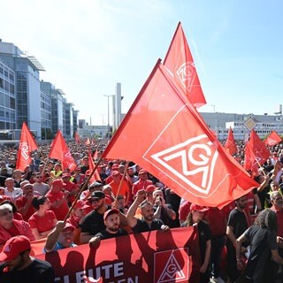 An einem Eingang zum Mercedes-Benz Werk demonstrieren mehrere tausend Mitarbeiter des Automobilherstellers Mercedes-Benz mit Fahnen der Gewerkschaft IG Metall gegen den  Sparkurs.