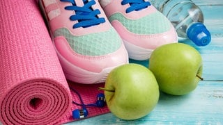 Turnschuh, Sportmatte, Äpfel und Wasserflaschen