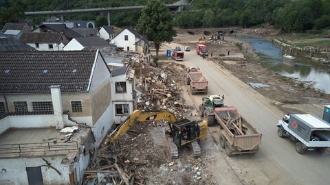 Ein Bagger reißt in Altenburg in der Verbandsgemeinde Altenahr Häuser ab, die durch die Flutkatastrophe zerstört wurde 