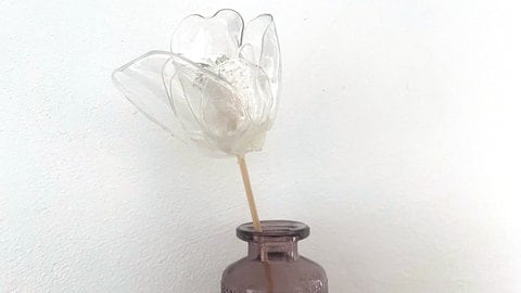 Dann die vier kleineren Blütenblätter um das Innere der Blüte festkleben. Zum Schluss die vier größeren Blütenblätter versetzt zu den inneren Blütenblättern festkleben. 
