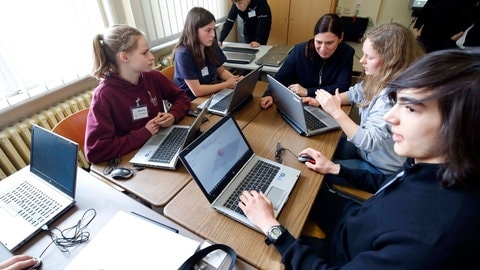 Schülerinnen und Schüler sitzen in einer Gruppe zusammen