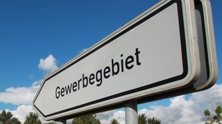 Hinweisschild mit der Aufschrift Gewerbegebiet: Der Einbruch der Gewerbesteuern trifft bundesweit viele Kommunen hart – auch in Baden-Württemberg müssen viele Städte und Gemeinden sparen.