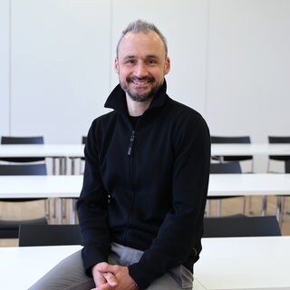 Gesundheitsökonom Jan-Marc Hodek lacht in die Kamera. In SWR1 Leute spricht er über die GKV-Reform.