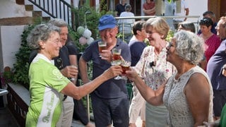 Menschen stoßen in Leinsweiler auf die deutsch-französische Partnerschaft mit Noyers-sur-Serein an