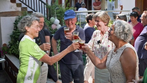Menschen stoßen in Leinsweiler auf die deutsch-französische Partnerschaft mit Noyers-sur-Serein an