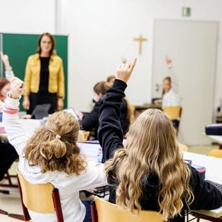 Schülerinnen einer sechsten Klasse melden sich in einem Klassenraum (Archivbild)